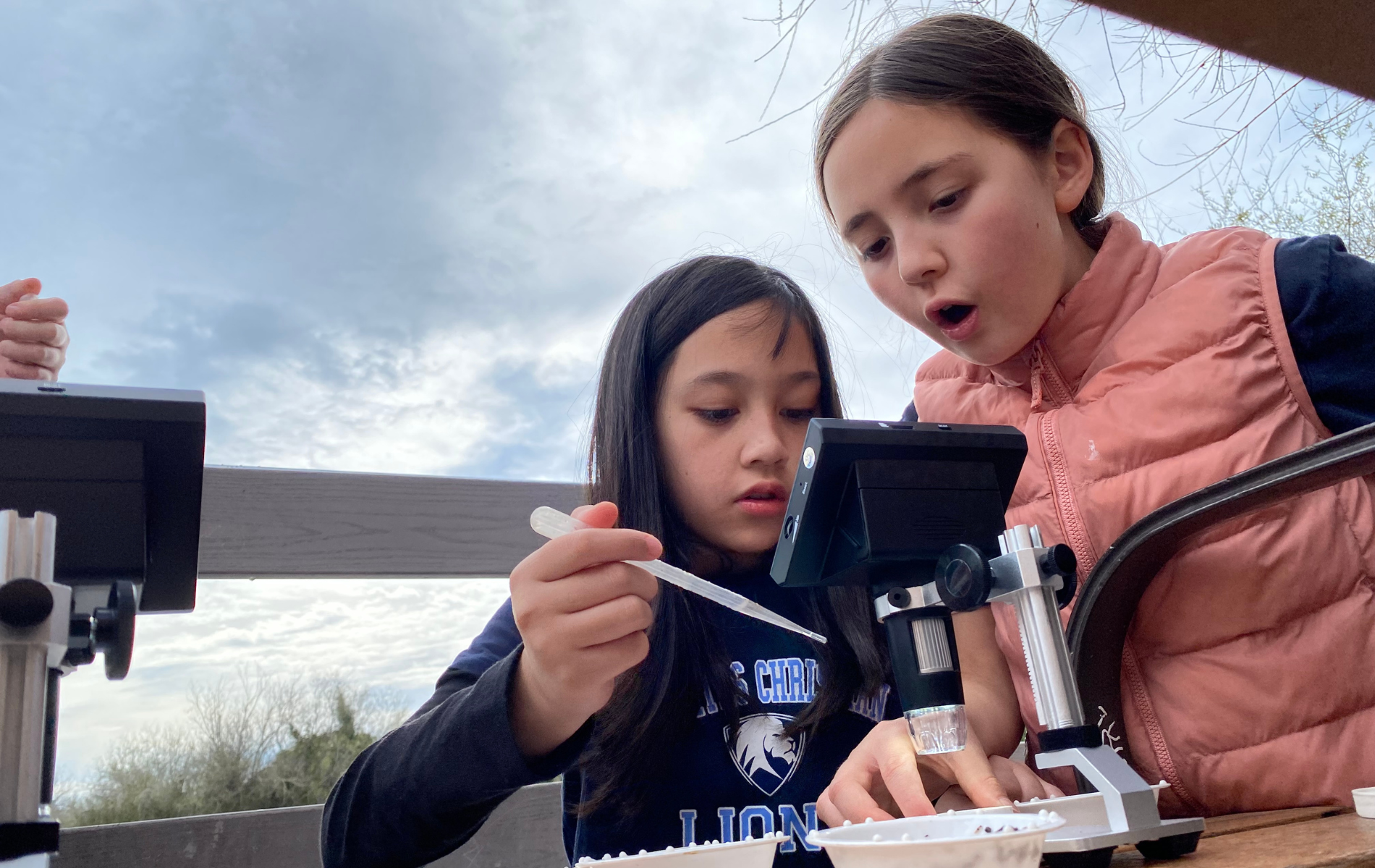 Two girls looking through a microscope