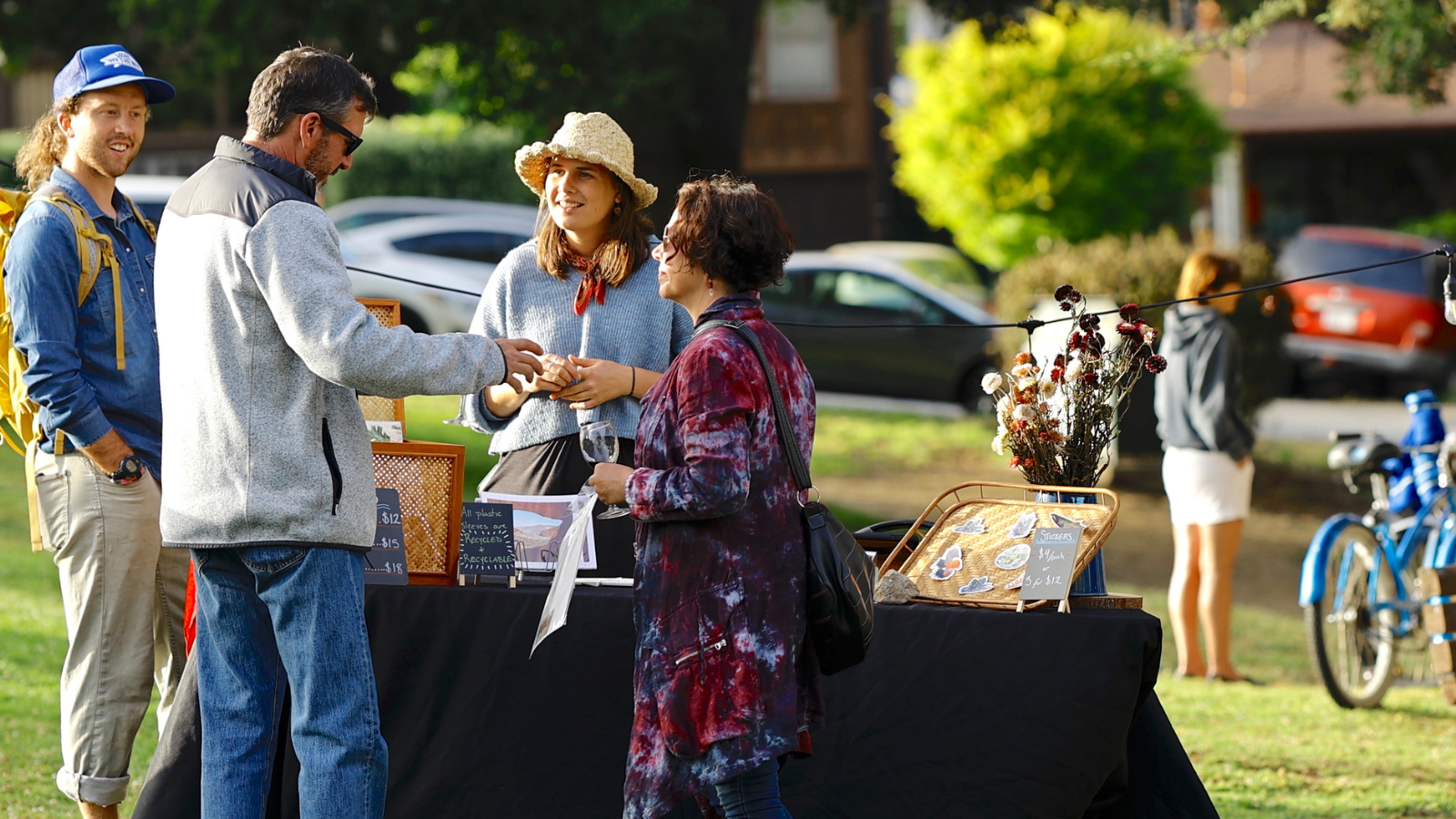 3 people talking to an artist at her outdoor booth