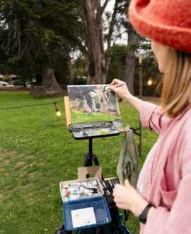 close up of a woman painting an outdoor scene