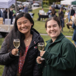 two people holding glasses of wine outside