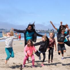 people jumping on a sandy beach