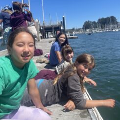 girls laying on a dock in a harbor