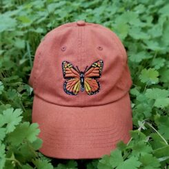 orange baseball hat with embroidered monarch butterfly on the front